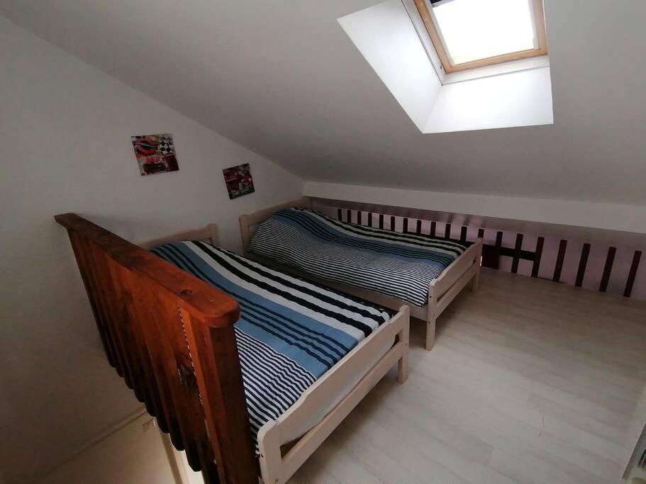 two twin beds in a room with a window at LE BLANC, AGREABLE MAISON DE CENTRE VILLE in Le Blanc