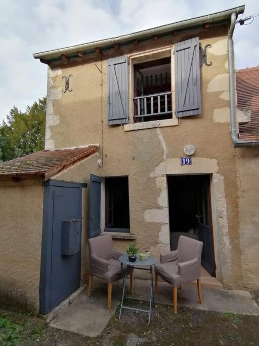 two chairs and a table in front of a building at LE BLANC, AGREABLE MAISON DE CENTRE VILLE in Le Blanc