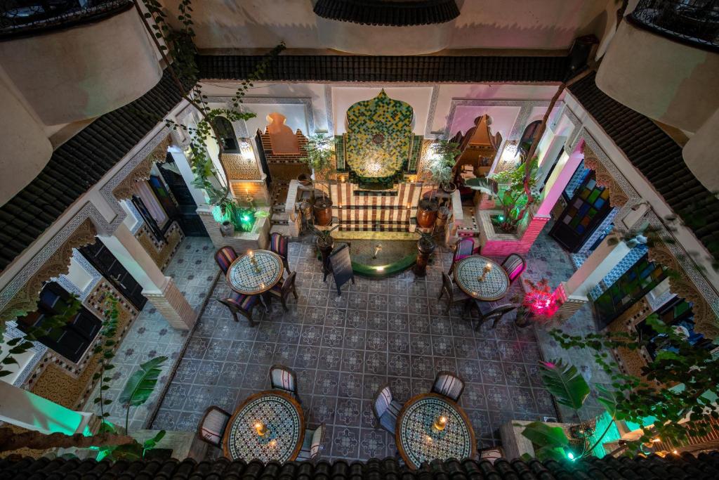 widok na restaurację ze stołami i krzesłami w obiekcie Riad Arabesque w Marakeszu