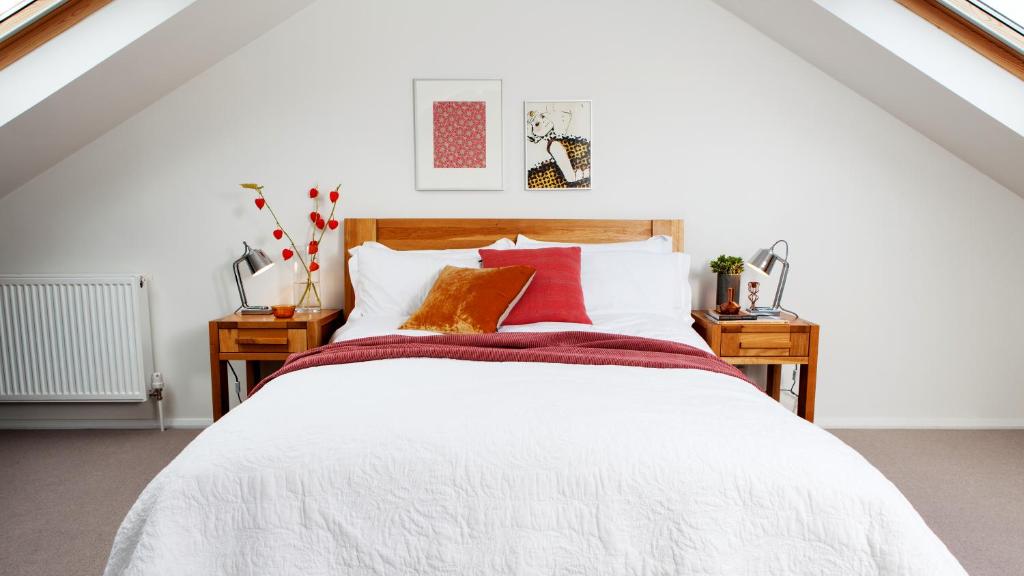 a bedroom with a white bed with red pillows at St. Peter's Close in London