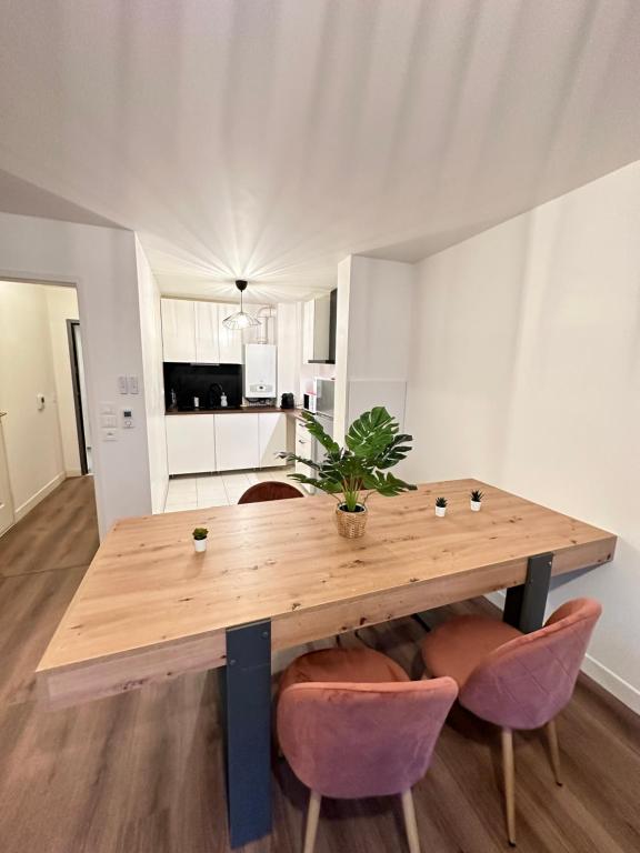 uma mesa de madeira com uma planta em vasos num quarto em Magnifique appartement à Bagnolet-Paris 102 em Bagnolet