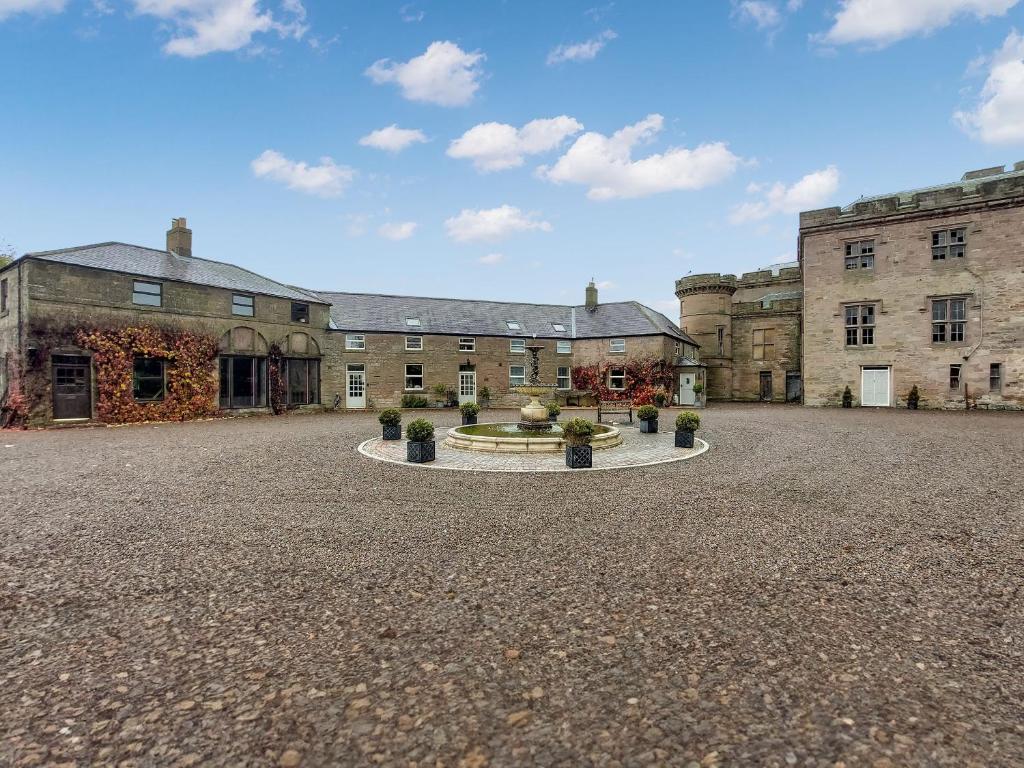 a large courtyard with a fountain in front of a building at Cottage 2 - Uk45645 in Lowick