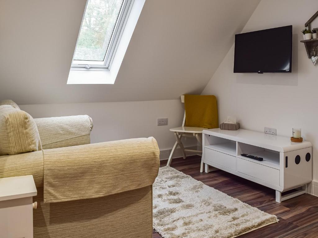 a living room with a couch and a tv at The Loft At Tall Trees in Welton