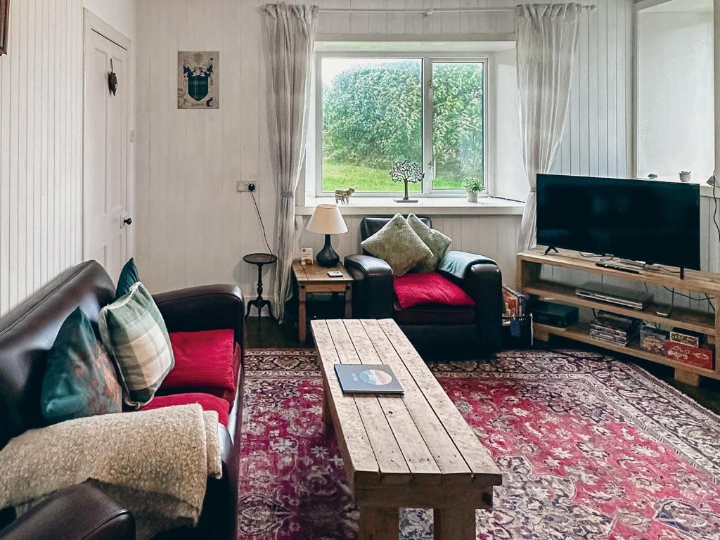 a living room with a couch and a tv at South Lochs in Marvig