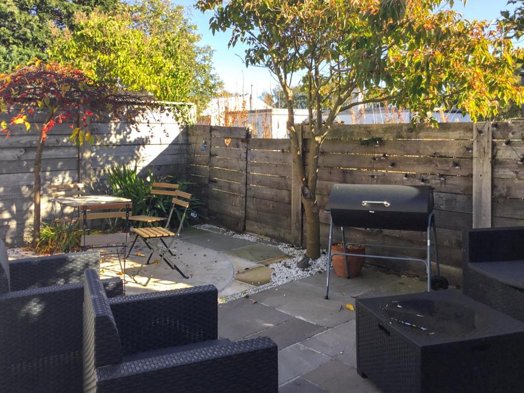 a backyard with a grill and a fence at Railway Cottage in Bishops Castle