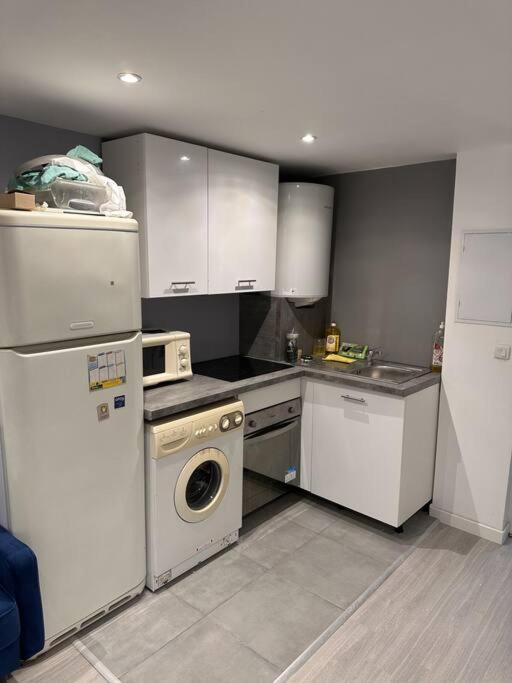 a kitchen with white appliances and a washer and dryer at Appart T2 Confort près de Disney in Monthyon