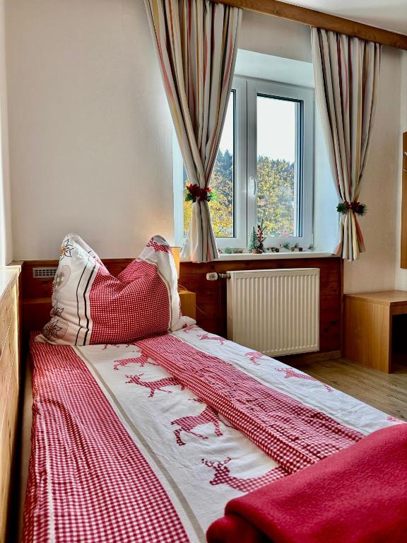 a bedroom with a bed with a red and white blanket at Central Kitz Apartments in Kitzbühel