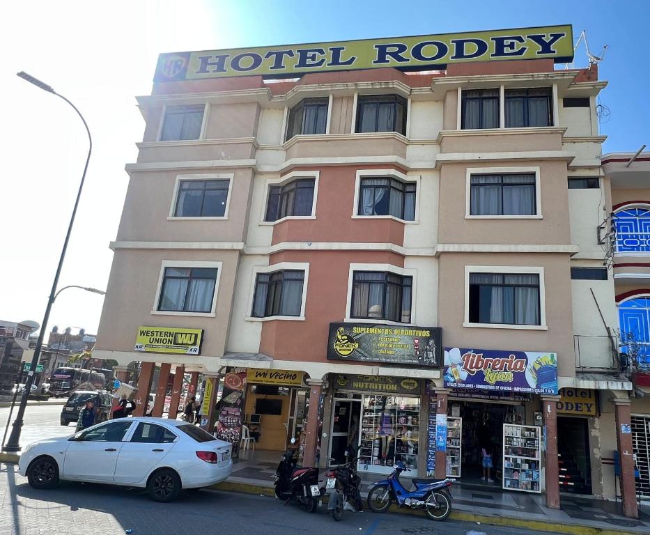 un edificio de hotel con un coche aparcado delante de él en Hotel RODEY en Huaquillas