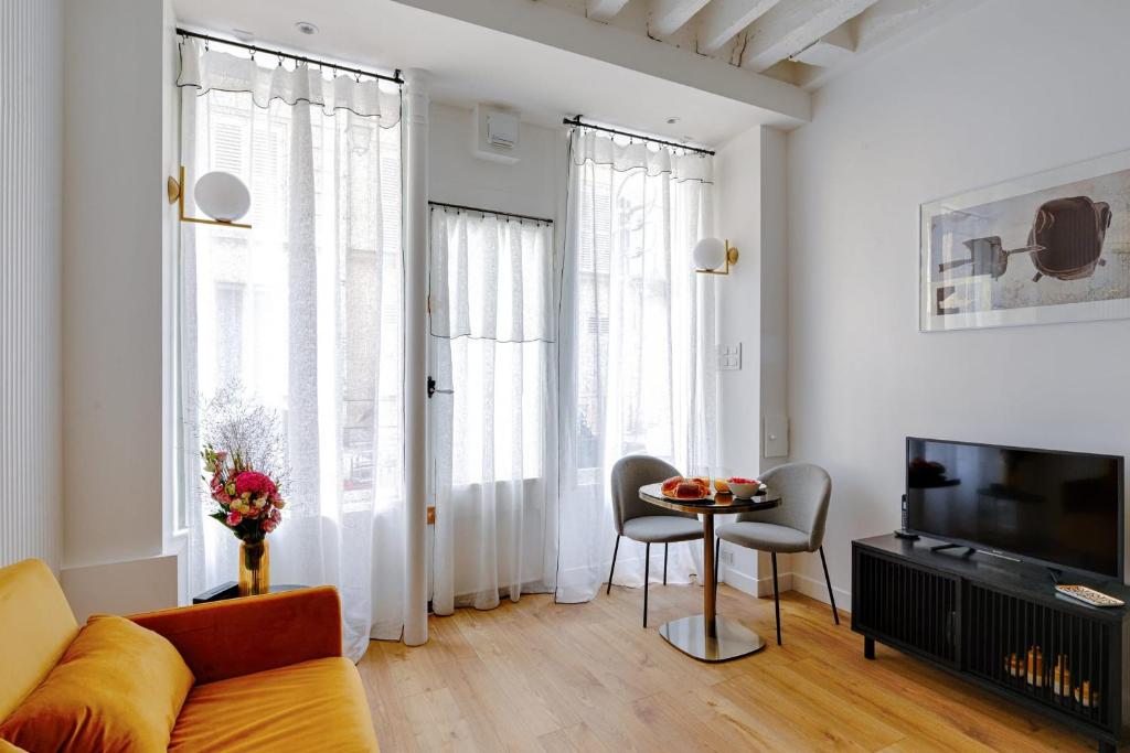a living room with a couch and a table at Designer apartment on St Louis Island in Paris - Welkeys in Paris