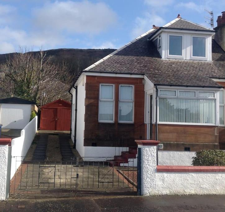 a brown and white house with a red door at Cumbrae View House (Licence no NA00109F) in Largs