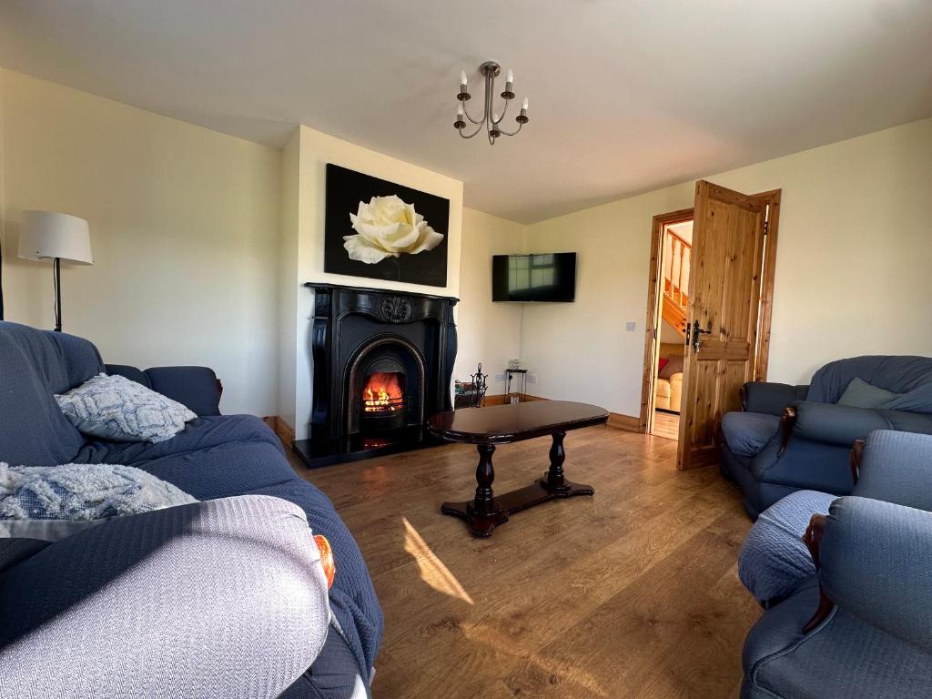 a living room with two blue couches and a fireplace at House in Glenties in Glenties