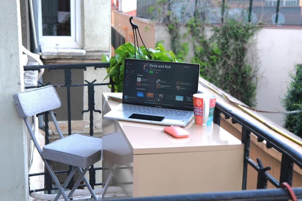 un ordenador portátil sentado en una mesa en un balcón en Historical apt-w.balcony in the hearth of Istanbul, en Estambul