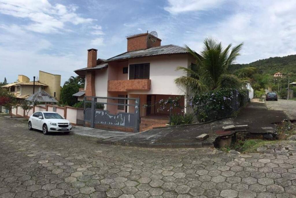 um carro branco estacionado em frente a uma casa em Casa Praia Brava Florianópolis. em Florianópolis