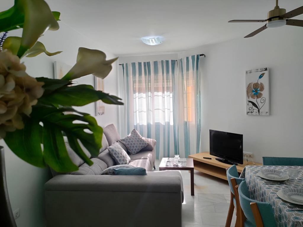 a living room with a couch and a table at Casita de la Infanta by Sanlúcar Housing in Sanlúcar de Barrameda