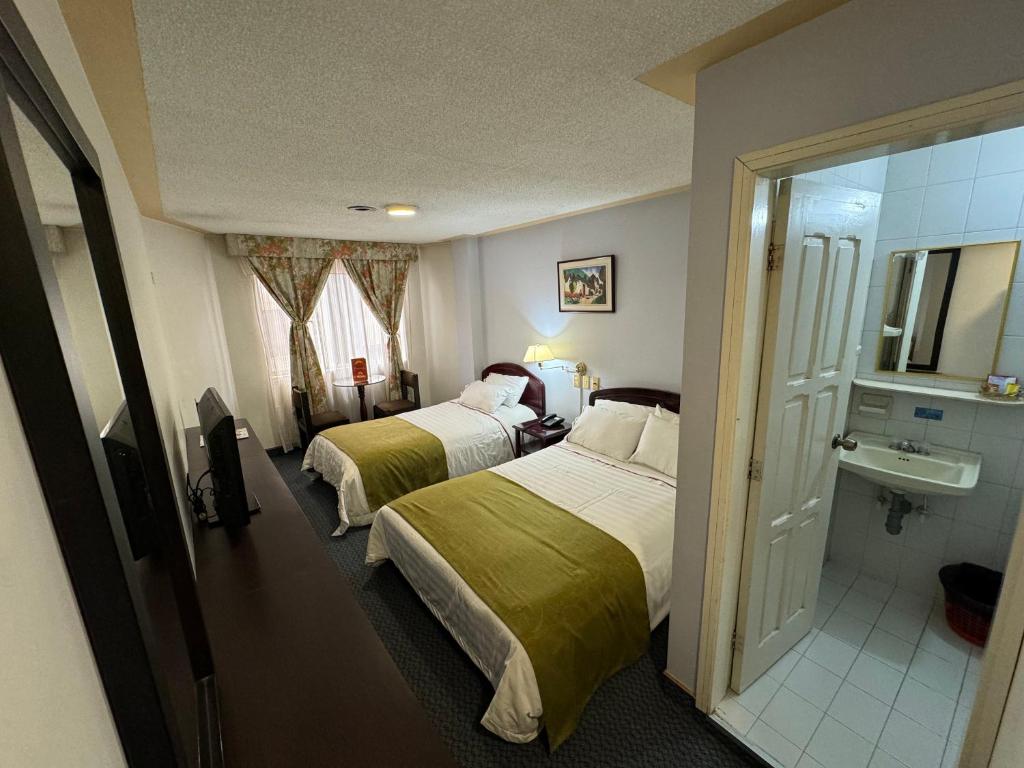 Habitación de hotel con 2 camas y baño en Hotel Los Andes, en Ipiales