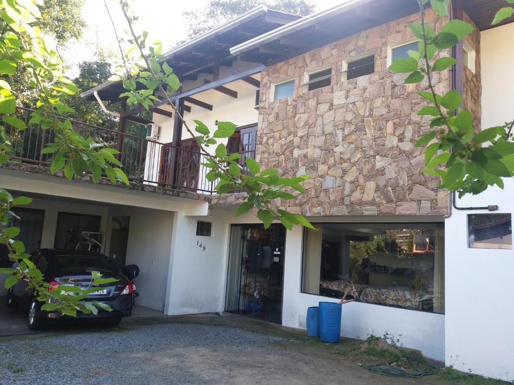 a house with a car parked in front of it at CASA ACONCHEGANTE PROXIMO VILA GERMÂNICA in Blumenau