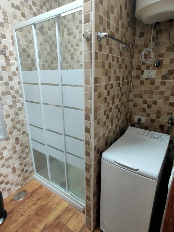 a shower in a bathroom with a washing machine at Apartamento Almogrote in San Isidro