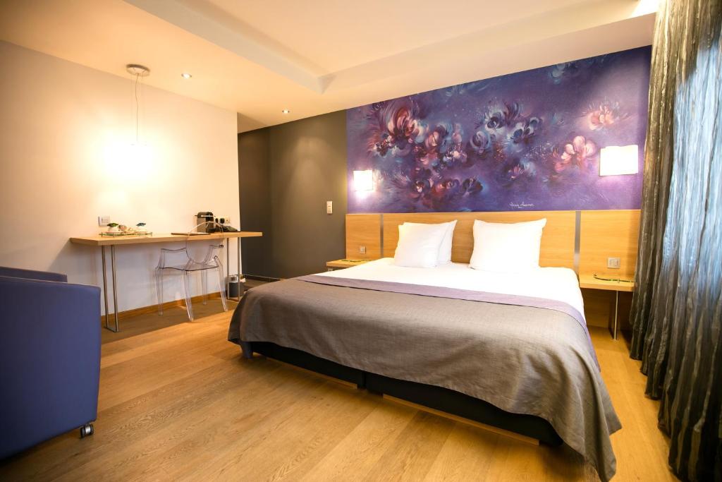 een slaapkamer met een bed met een schilderij aan de muur bij Hôtel-Restaurant L'Auberge in Spa