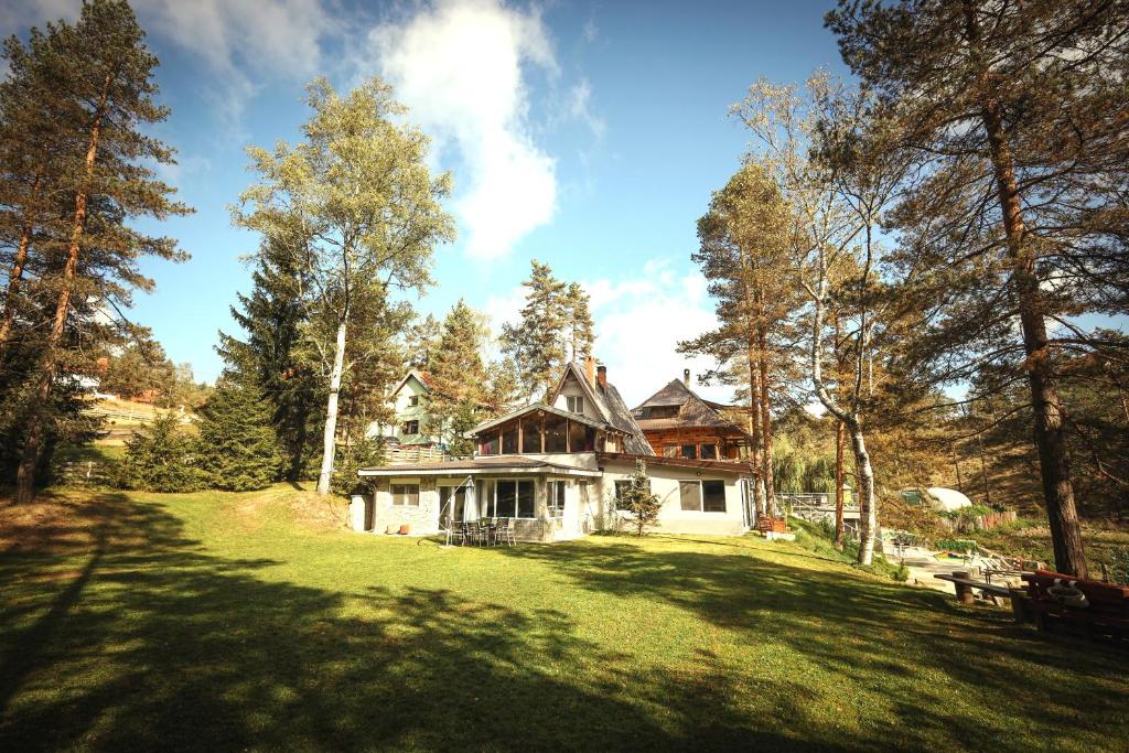 een huis in het midden van een veld met bomen bij Vila POGLED Wellness i spa in Divčibare