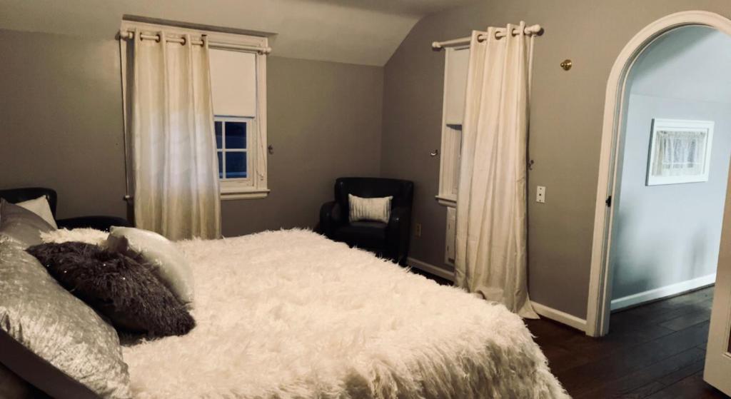 a bedroom with a large white bed and a window at Hideaway Country Inn in Bucyrus