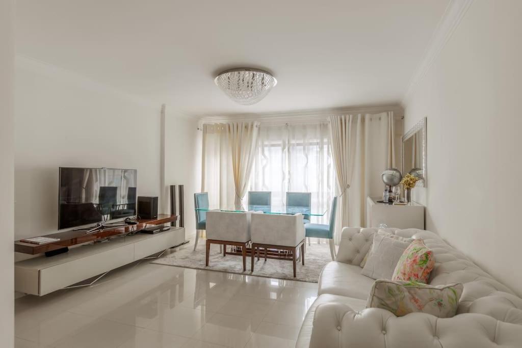 un soggiorno bianco con divano e TV di Maison Soleil Oeiras a Oeiras