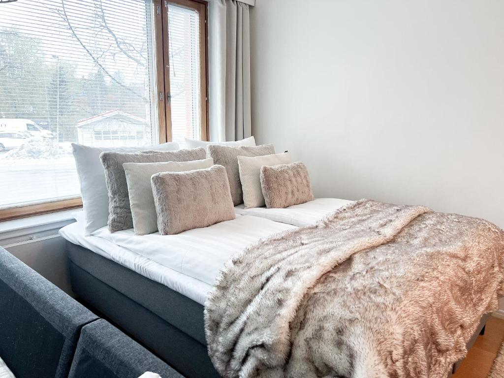 a white couch with a blanket and a window at Cozy city suites in Rovaniemi