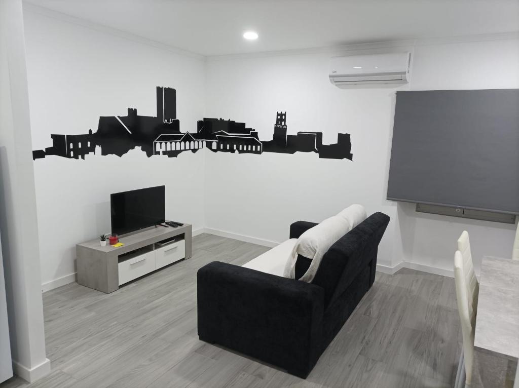 - un salon avec un canapé noir et une télévision dans l'établissement Casa do Ferrador, à Moura