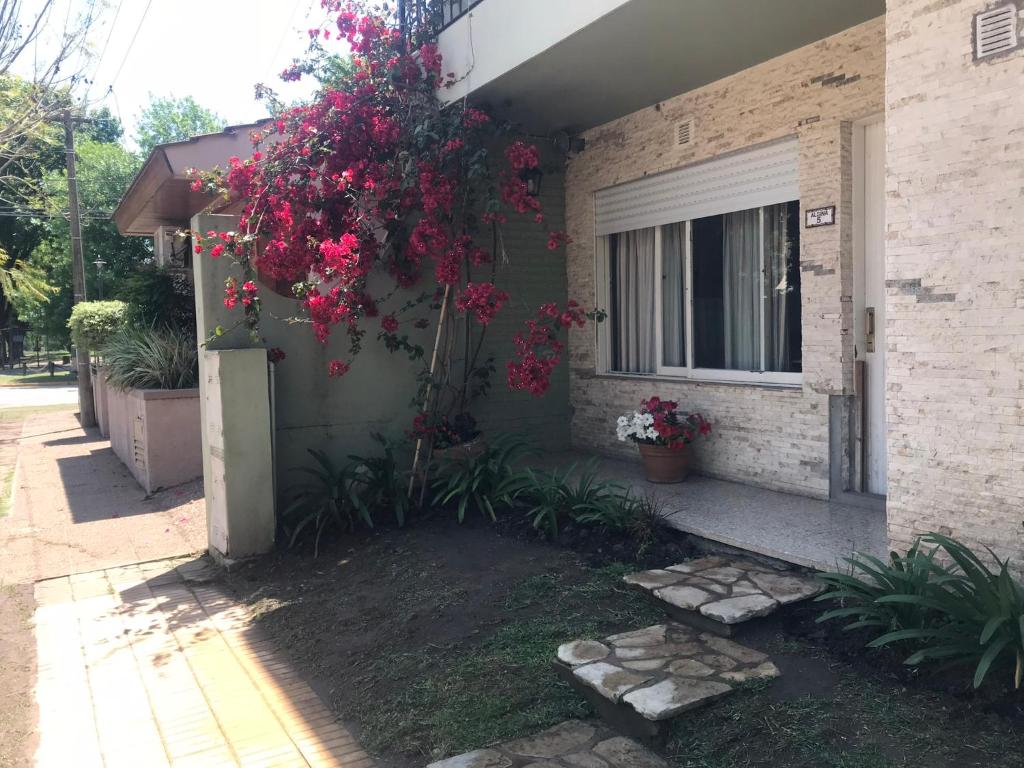 una casa con flores rojas a un lado. en Boulevard Alsina 5 en San Antonio de Areco
