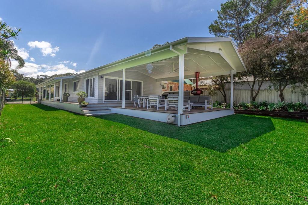 a house with a covered porch on a lawn at Eurie Eurie on Beachview in Berrara