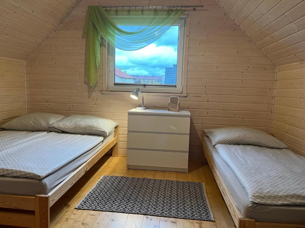 two beds in a room with a window at Domki Słoneczka in Sarbinowo