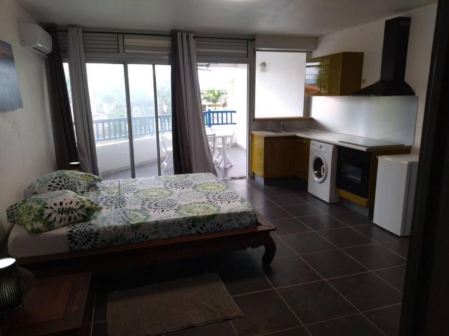 Zimmer mit einem Bett und einer Küche mit einem Balkon in der Unterkunft Bleu Azur Diamant in Le Diamant