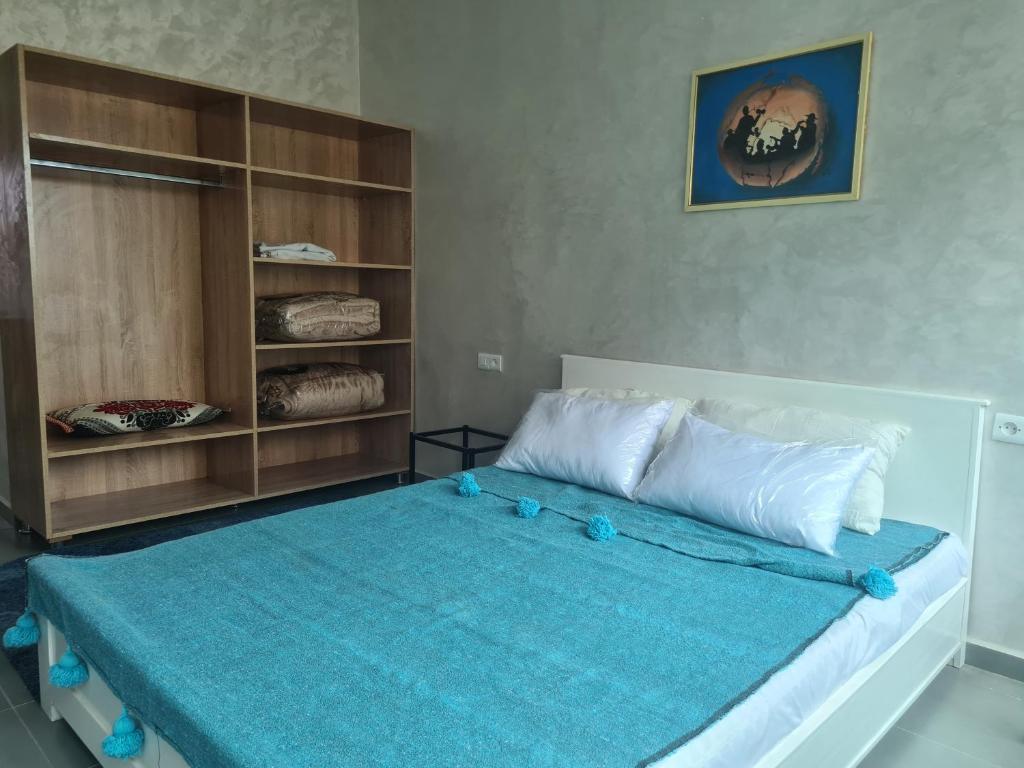 um quarto com uma cama com um cobertor azul em comme chez vous em Fez