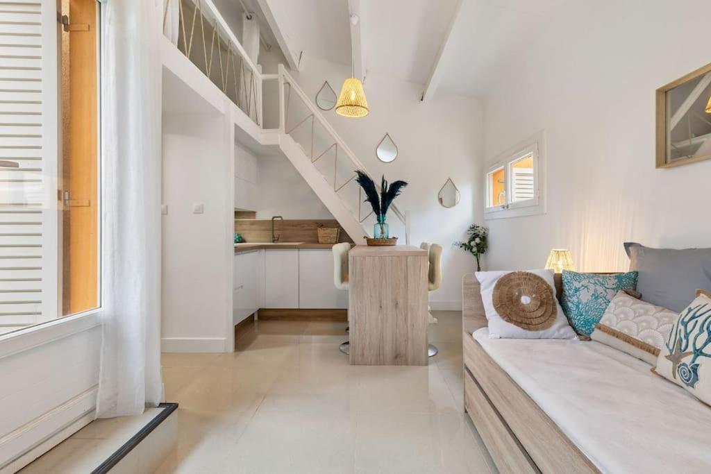 un salon avec un canapé et un escalier dans l'établissement Appartement Pinède proche Village Naturiste, au Cap d'Agde