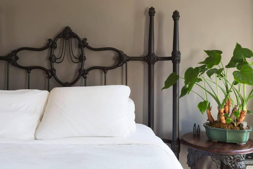 a bed with a pillow and a plant on a table at Sunny Stylish West Village Condo in New York