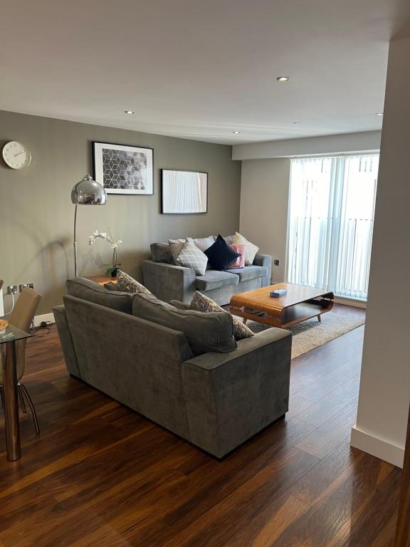 a living room with a couch and a table at Stunning Manchester City Centre Apartment! Ideal for small groups in Manchester