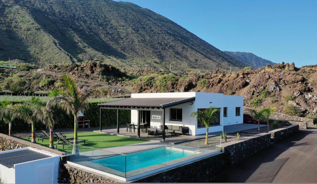 una casa con piscina frente a una montaña en Casa La Picota, en Los Llanillos