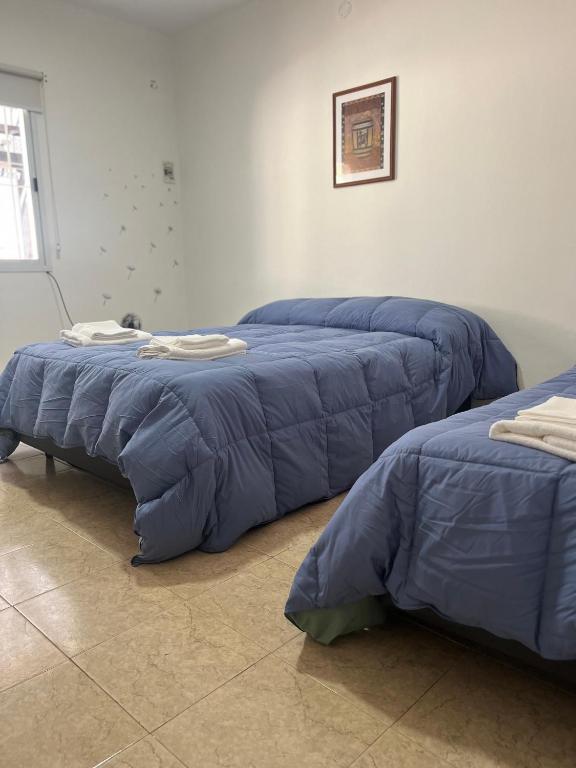 three blue comforter beds sitting in a room at Apart Entre Valles in Chilecito