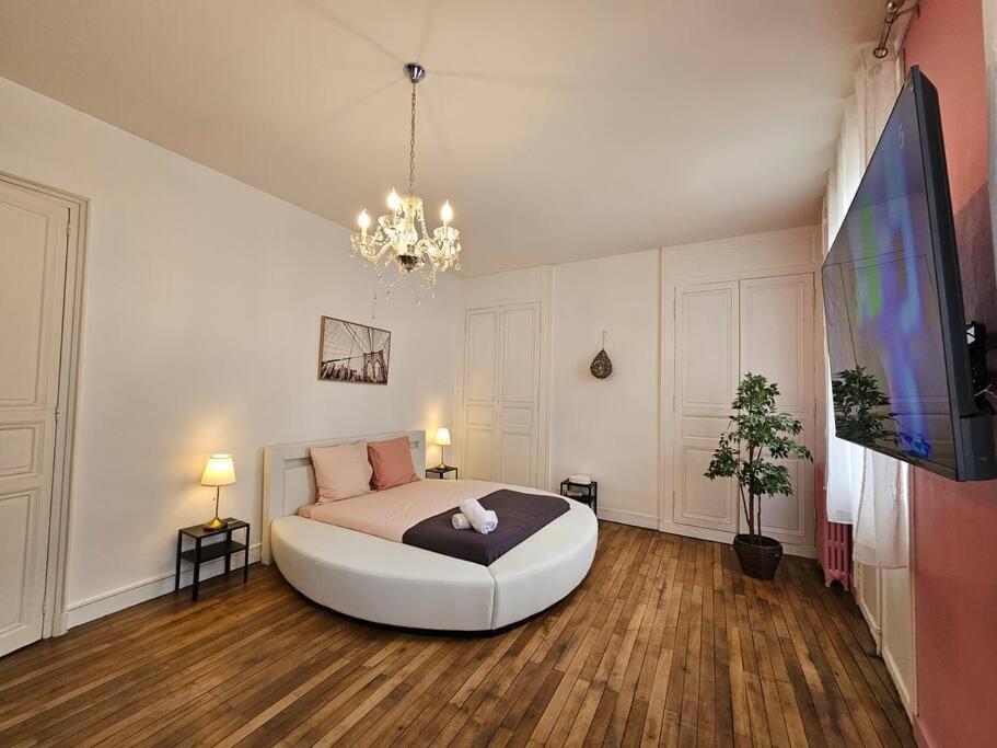 une chambre avec un grand lit et une télévision à écran plat dans l'établissement Elegencia-T2 de charme-Hyper centre-Fibre, à Angers