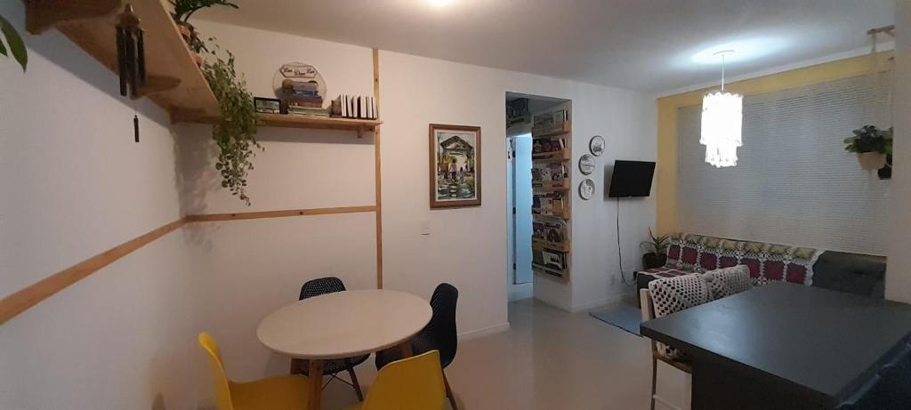 a room with a table and a table and chairs at Apartamento aconchegante em Itajaí in Itajaí