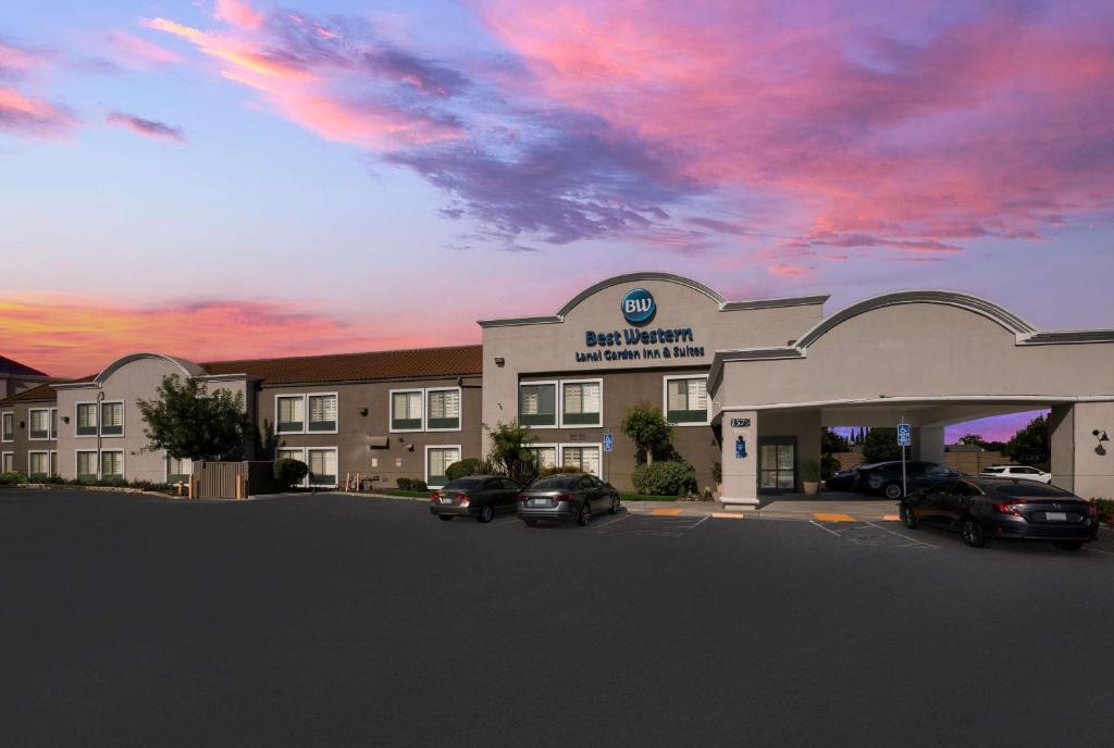 a hotel with cars parked in a parking lot at Best Western Lanai Garden Inn & Suites in San Jose