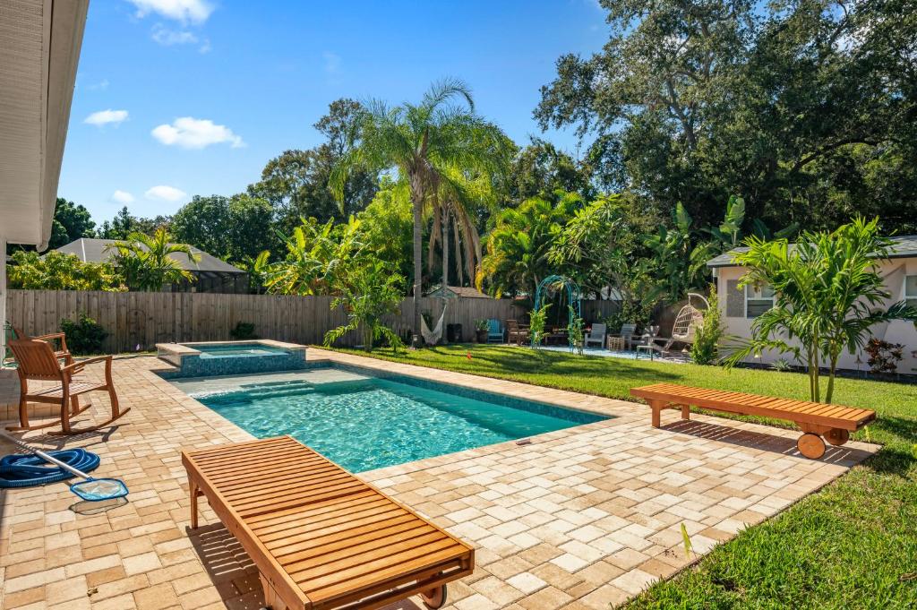 un patio trasero con una piscina con un banco y una mesa en Villa Maria Salt Sun 7 minutes to Indian Rocks Beach, en Largo