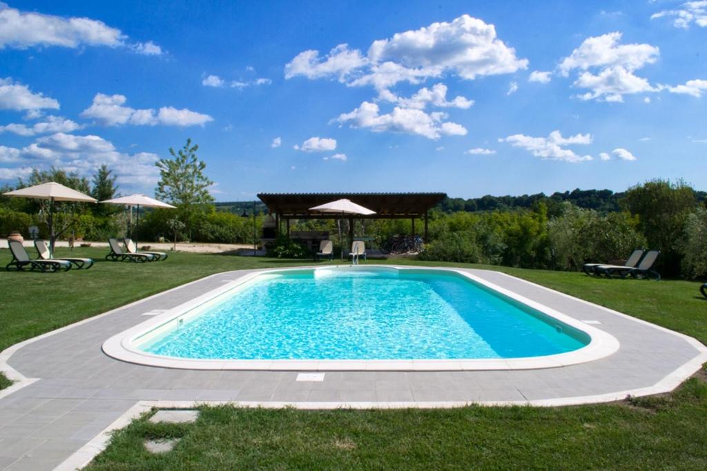 a swimming pool in a yard with a gazebo at Poggio Degli Olivi in Saturnia