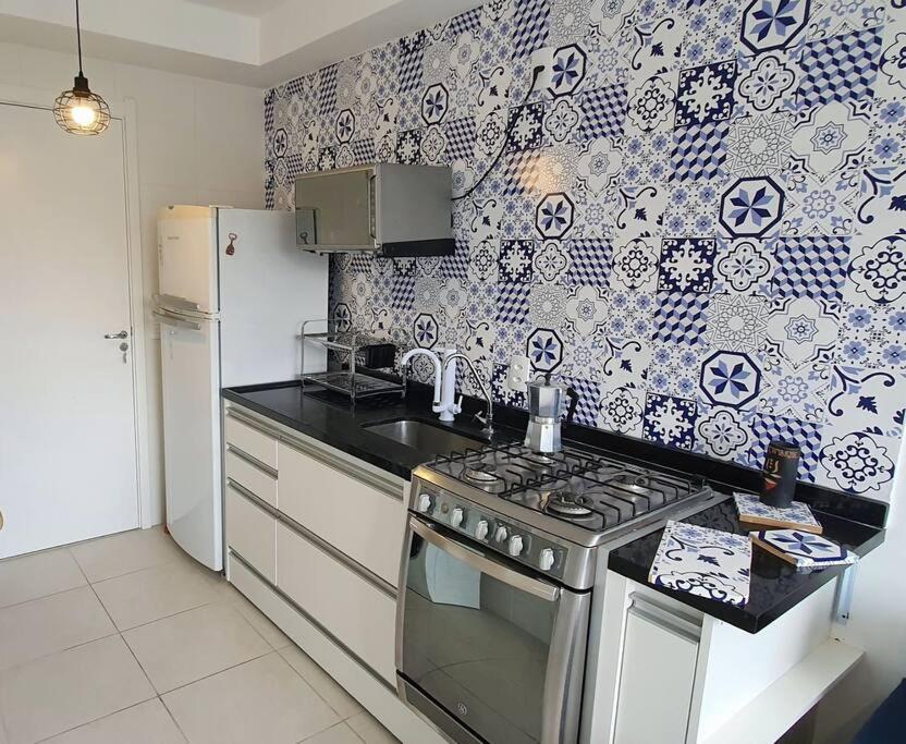 a kitchen with a stove and a refrigerator at Laguna Linda Vista in São Paulo