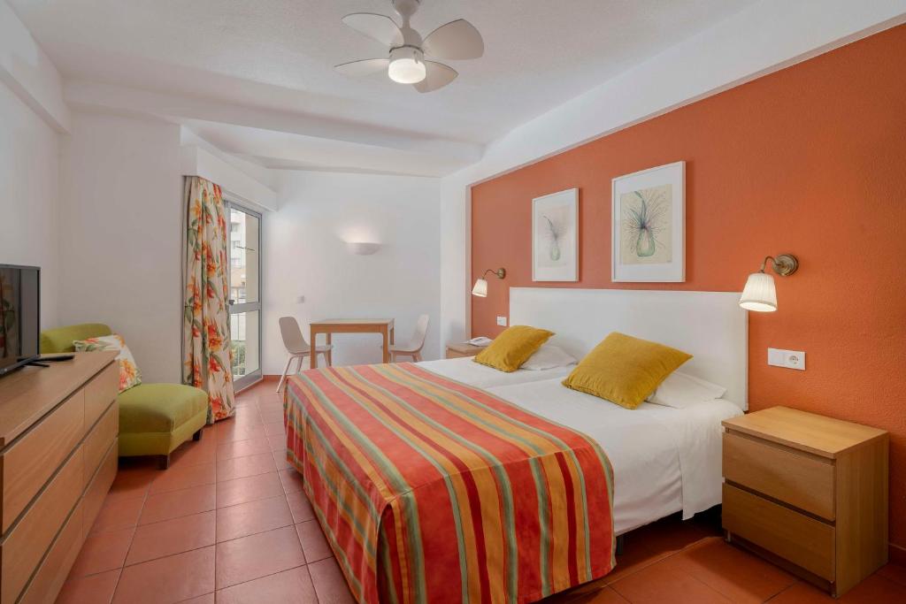 um quarto de hotel com uma cama e uma televisão em Florasol Residence Hotel - Dorisol hotels no Funchal