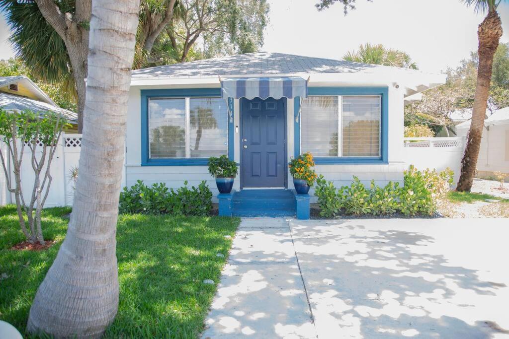 una casa con una puerta azul y dos palmeras en Two bedroom ranch with private deck close to beach, en Lake Worth