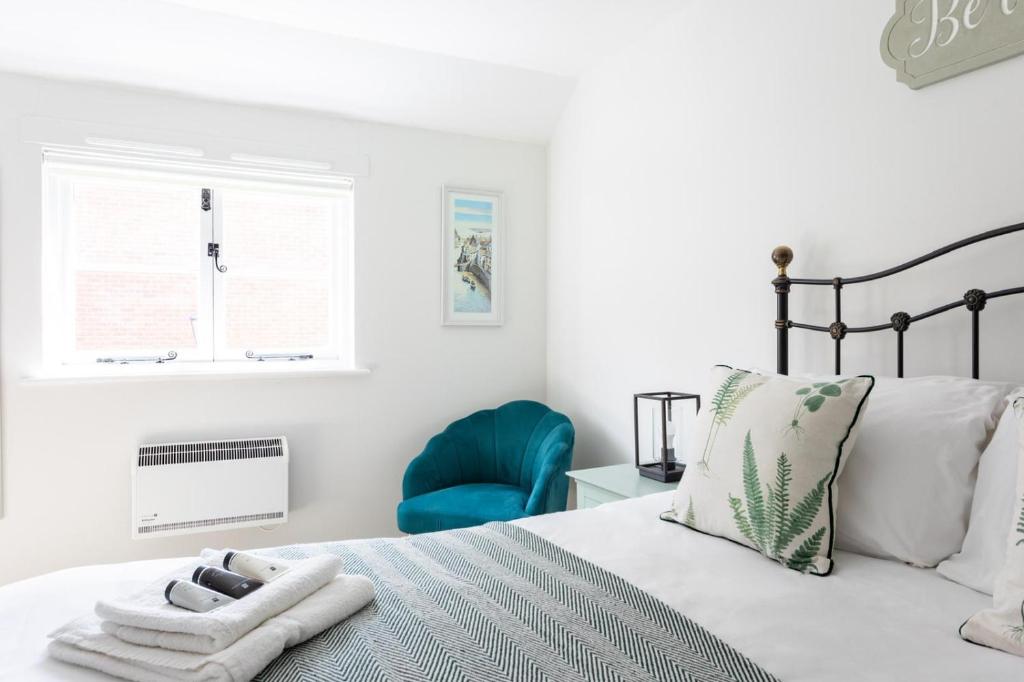 sypialnia z łóżkiem i niebieskim krzesłem w obiekcie Maldon Executive Apartments w mieście Maldon