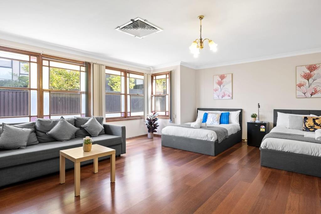 a living room with two couches and a table at Quadruple Room w Ensuite in Gordon near Train & Bus in Pymble