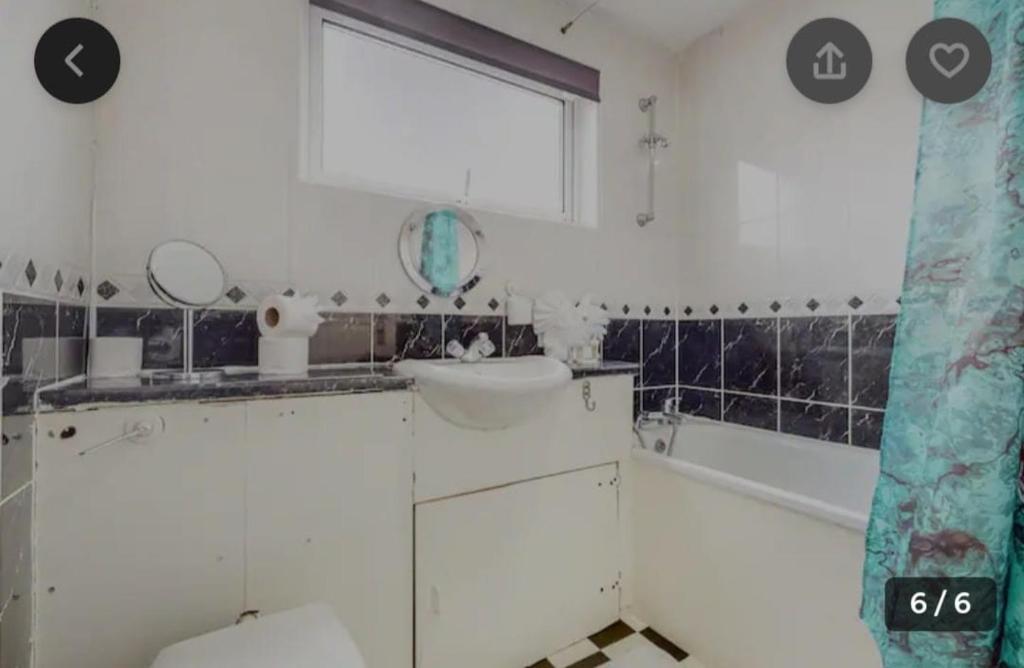 La salle de bains est pourvue d'un lavabo, de toilettes et d'une baignoire. dans l'établissement Richmond London 2 bed room Appartement, à Londres