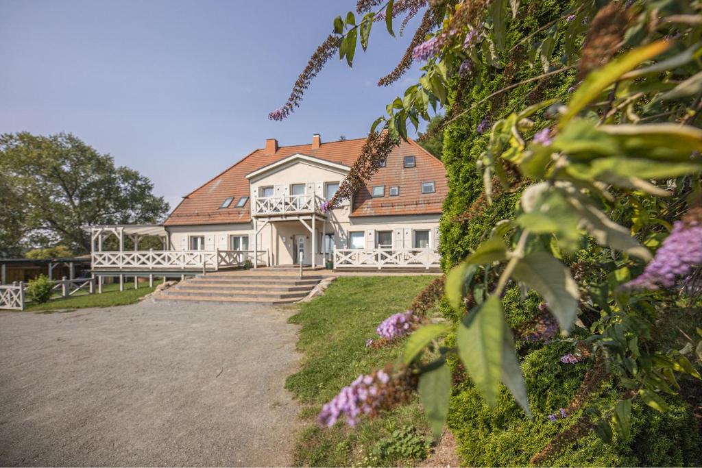 a large white house with a red roof at Ruhig und idyllische Lage, strandnah, gratis Nutzung vom AHOI Erlebnisbad und Sauna in Sellin - Gutshaus Silvitz FeWo 02 in Bergen auf Rügen