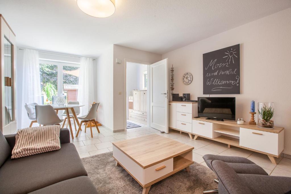 sala de estar con sofá, TV y mesa en Zwischen den Stränden en Dörphof